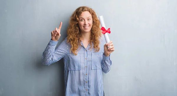 Joven Pelirroja Negocios Mujer Sobre Gris Grunge Pared Celebración Diploma —  Fotos de Stock