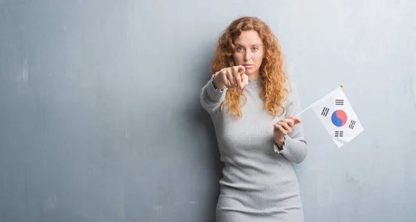 Giovane Donna Rossa Sopra Grigio Grunge Muro Tenendo Bandiera Della — Foto Stock