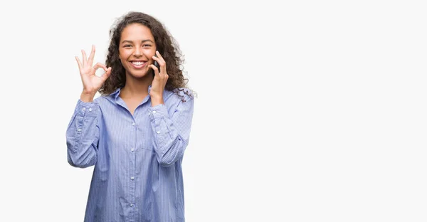 Young Hispanic Woman Using Smartphone Doing Sign Fingers Excellent Symbol — Stock Photo, Image