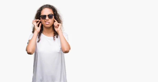 Νεαρή Γυναίκα Ισπανόφωνος Φορώντας Γυαλιά Ηλίου Καλύπτουν Αυτιά Δάχτυλα Ενοχλημένος — Φωτογραφία Αρχείου