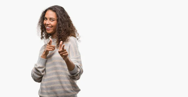 美しい若いヒスパニック系女性の幸せと面白い顔でカメラに指を指してストライプ セーターを身に着けています 良いエネルギーとヴァイブス — ストック写真