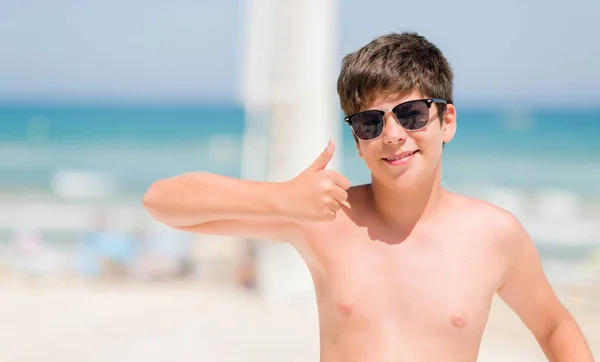 笑顔の サイン 優秀な兆候を親指をやって幸せのビーチで休日に若い子 — ストック写真