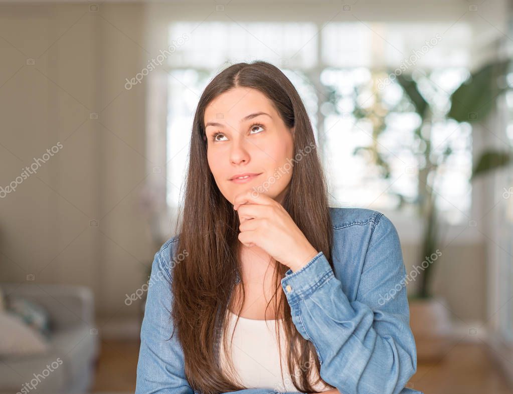 Young beautiful woman at home serious face thinking about question, very confused idea