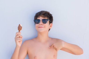 Kendisi için sürpriz yüz işaret parmağı ile dondurma yeme tatil günlerinde genç çocuk