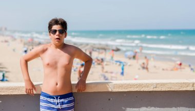 Bir sürpriz yüz, korkuyor ve heyecanlı korku ifadesi ile şok korkmuş sahilde tatil günlerinde genç çocuk