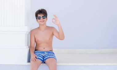 Parmak, mükemmel sembolü ile ok işareti yapıyor tatil günlerinde genç çocuk