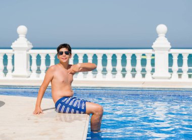 Kendisi için sürpriz yüz işaret parmağı plajda yüzme havuzunda genç çocuk tatilde