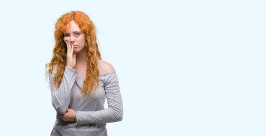 Genç Kızıl saçlı kadın düşünme seyir yorgun ve sıkılmış çapraz silah depresyon sorunları ile.