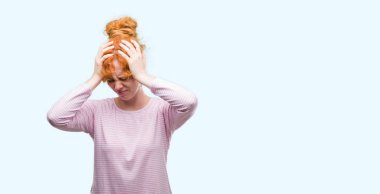 Genç Kızıl saçlı kadın çünkü umutsuz ve stresli baş ağrısı acı acı ve migren. Ellerini kafasına.