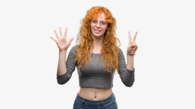 Gösterilen ve parmakları ile işaret genç Kızıl saçlı kadın kendinden emin ve mutlu gülümseyerek süre yedi numara.