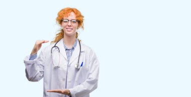 Doktor Tekdüzen eller eller büyük gösterilen ve büyük boy işareti, ölçü birimi sembolü ile giyen genç Kızıl saçlı kadın. Kameraya bakarak gülümsüyordu. Ölçüm kavramı.