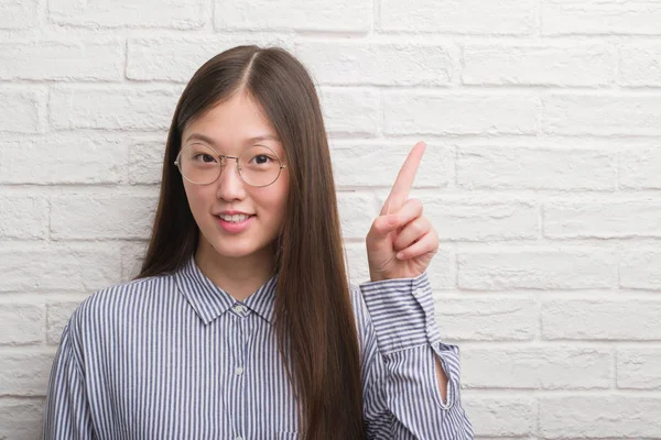 Joven Mujer Negocios China Sobre Pared Ladrillo Sorprendida Con Una —  Fotos de Stock