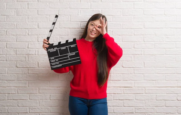 年轻的中国妇女在白色砖墙上伸出舌头 高兴地用滑稽的表情表达出来 情感概念 — 图库照片