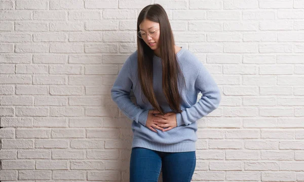 Joven Mujer China Sobre Pared Ladrillo Blanco Que Sobresale Lengua —  Fotos de Stock