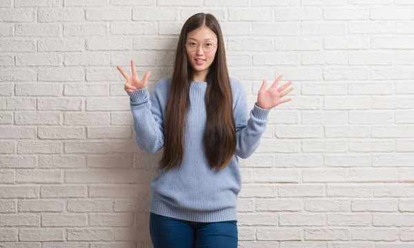 舌を付着白レンガ壁を越えて若い中国女性を面白い表現に満足 感情の概念 — ストック写真