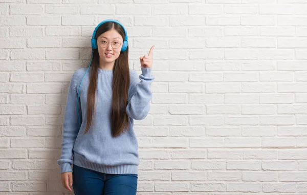 Mladá Číňanka Přes Cihlovou Zeď Nošení Sluchátek Překvapilo Nápad Nebo — Stock fotografie