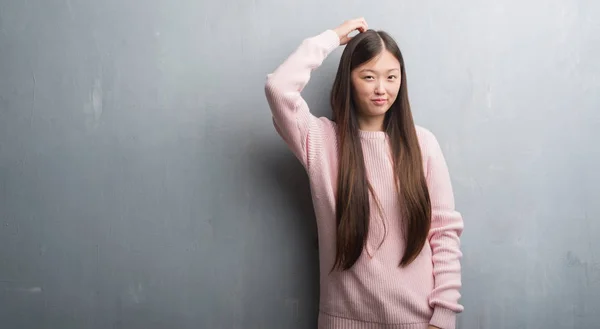 舌を付着白レンガ壁を越えて若い中国女性を面白い表現に満足 感情の概念 — ストック写真