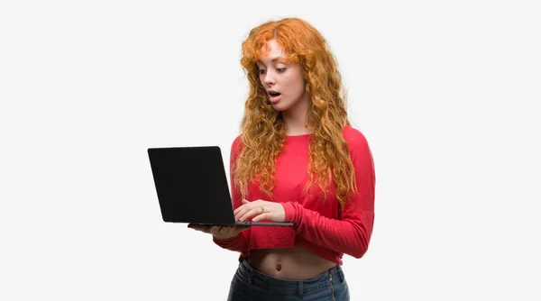 Young Redhead Woman Using Computer Laptop Scared Shock Surprise Face — Stock Photo, Image