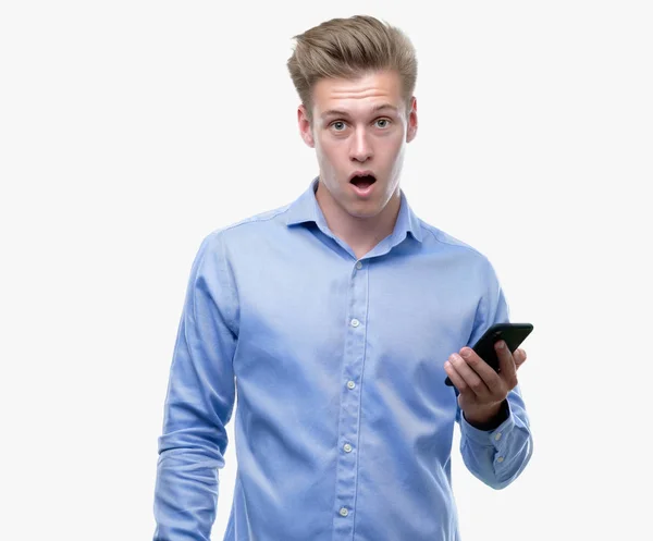 Jovem Homem Loiro Bonito Usando Smartphone Assustado Choque Com Rosto — Fotografia de Stock