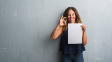 Parmak, mükemmel sembolü ile ok işareti yapıyor Bankası kağıt levha tutan orta yaş İspanyol kadın