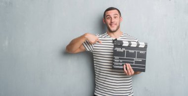 Beyaz delikanlı film fıçı tahtası sürpriz yüz işaret parmağı kendisine tutan gri grunge duvarın üzerinden