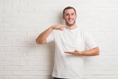 Beyaz tuğla duvar çılgın ve kızgın bağırarak ve agresif ifade ve silah kaldırdı bağırmaya üzerinde duran beyaz delikanlı. Hayal kırıklığı kavramı.