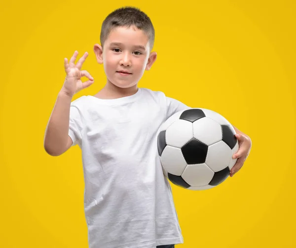 Ciemne Włosy Małego Dziecka Grając Piłki Nożnej Robi Znak Palcami — Zdjęcie stockowe
