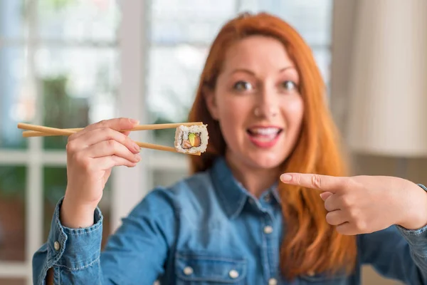 Ruda Kobieta Jedzenie Sushi Pomocą Pałeczki Bardzo Szczęśliwy Wskazując Dłoni — Zdjęcie stockowe