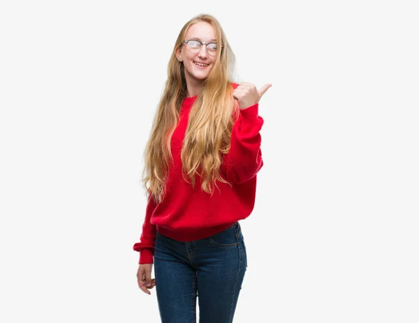 探していると親指側に上向きの幸せそうな顔を浮かべて赤いセーターを着ている金髪 代女性 — ストック写真