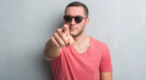 Joven Hombre Caucásico Sobre Pared Grunge Gris Con Gafas Sol —  Fotos de Stock