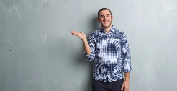 Kaukasische Jongeman Grijs Grunge Muur Lacht Vrolijk Presenteren Wijzen Niet — Stockfoto