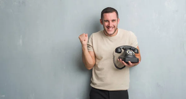 Ung Kaukasiska Man Över Grå Grunge Väggen Ringer Vintage Telefon — Stockfoto