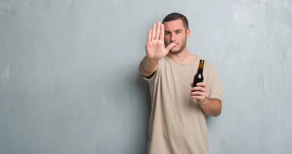 Young Caucasian Man Grey Grunge Wall Holding Bottle Beer Open — Stock Photo, Image