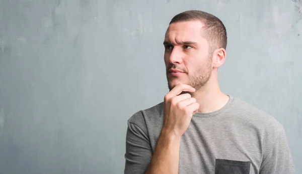 Young Caucasian Man Grey Grunge Wall Serious Face Thinking Question — Stock Photo, Image