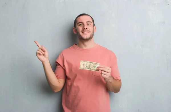 Junger Kaukasischer Mann Über Graue Grunge Wand Zeigt Zehn Dollar — Stockfoto