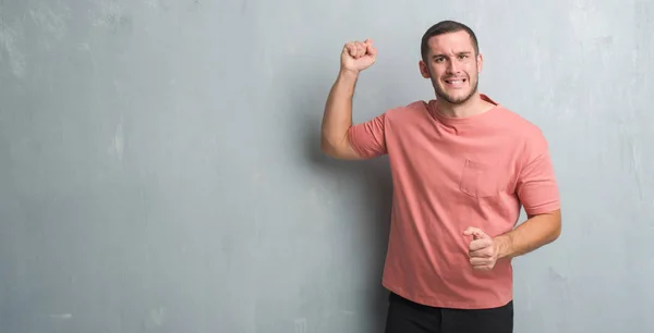 Joven Hombre Caucásico Sobre Pared Gris Grunge Enojado Loco Levantando — Foto de Stock