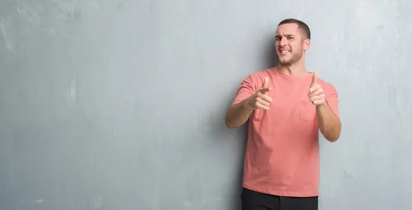 Joven Hombre Caucásico Sobre Gris Pared Grunge Señalando Los Dedos —  Fotos de Stock