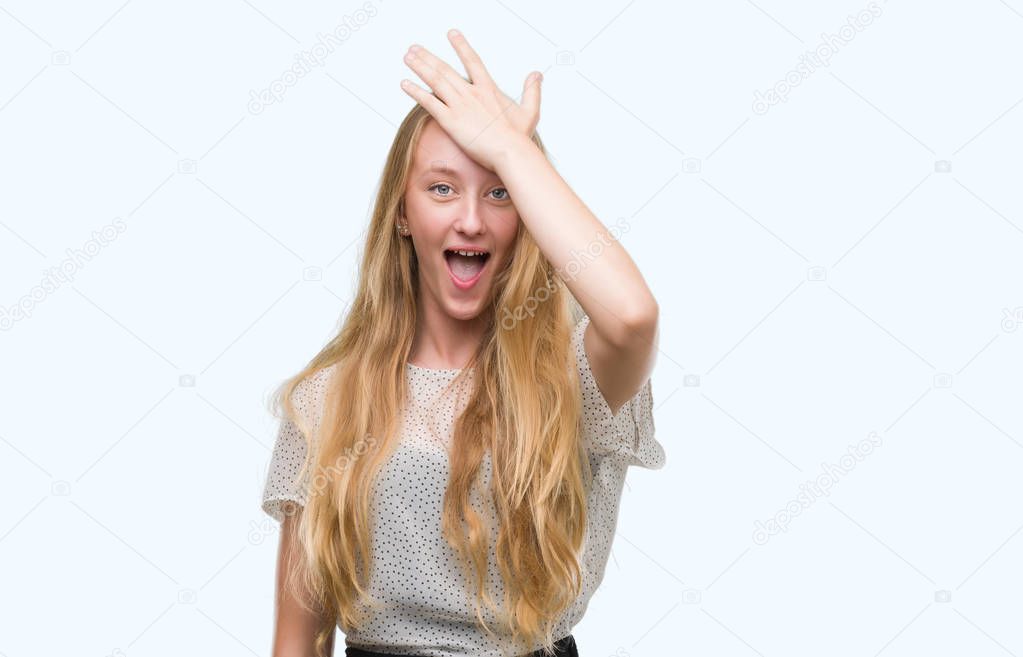 Blonde teenager woman wearing moles shirt surprised with hand on head for mistake, remember error. Forgot, bad memory concept.