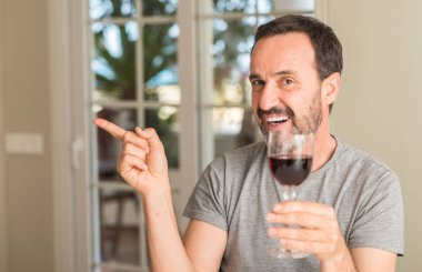 Bir bardak şarap çok mutlu el ve parmak ile tarafına işaret içme orta yaş erkek