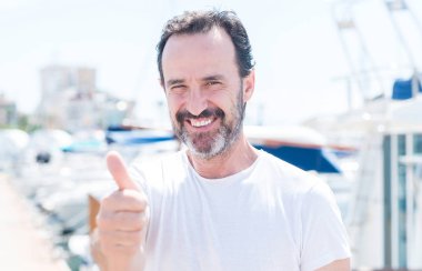 Yakışıklı orta yaş erkek Marina ok işareti, başparmak ile parmak, mükemmel işareti yapıyor kocaman bir gülümseme ile mutlu