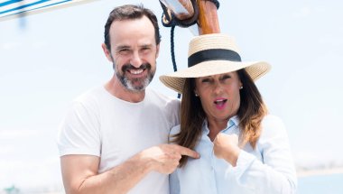 Orta yaş çift Yelkenli sürpriz ile seyahat eden kendine işaret parmağı yüz