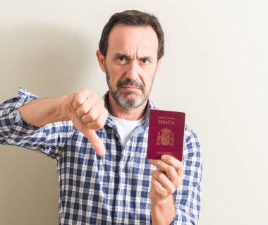 Kızgın yüz ile komuta sizde holding İspanyol pasaportu, başparmak aşağı, ret kavramı ile eksi işareti gösterilen sevmemek