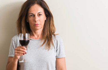 Orta yaş kadın acımak yüz ciddi düşünüyorum üstünde kendine güvenen bir ifade ile bir bardak kırmızı şarap içme