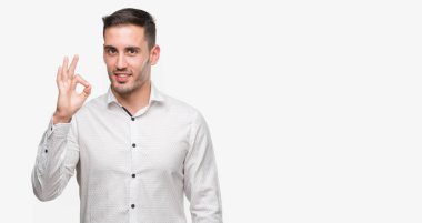 Yakışıklı genç iş adamı ok işareti parmaklar, mükemmel sembolü ile yapıyor