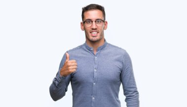 Hareketi el ile mutlu yaşasın yapıyor gözlüklü zarif yakışıklı genç. Kameraya bakarak başarı gösteren ile ifade onaylama.