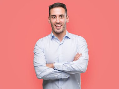 Yakışıklı genç işadamı mutlu yüz ile gülümseyerek kameraya seyir silah geçti. Olumlu bir kişi.