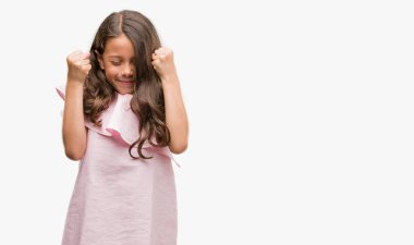 Esmer Latin kız pembe elbise kolları olan başarı için heyecanlı zafer kutluyor gülümseyen kaldırdı. Kazanan kavramı.