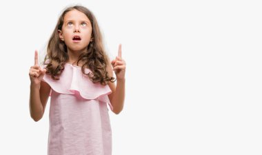 Pembe elbise esmer Latin kız hayran ve yukarıya bakıp parmakları ile işaret şaşırttı ve silah kaldırdı.