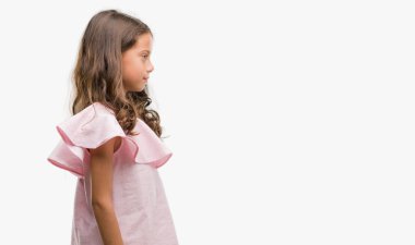 Esmer Latin kız tarafına, seyir pembe elbise dinlenmek doğal yüz emin gülümseme ile pozuyla profil.