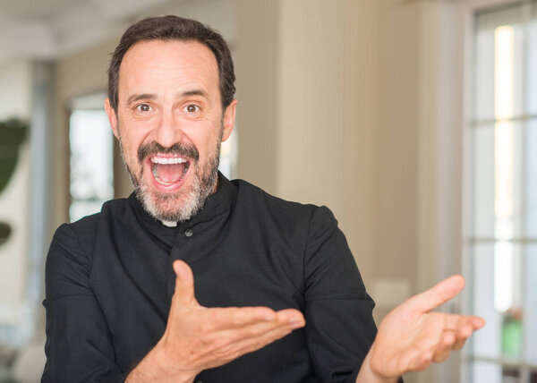 Christian priest man very happy pointing with hand and finger